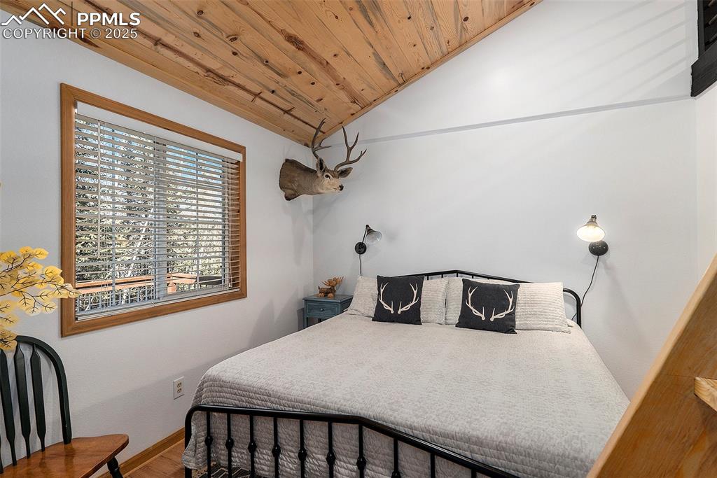 Image 15 of 25: Bedroom featuring wooden ceiling, lofted ceiling, and wood finished floors