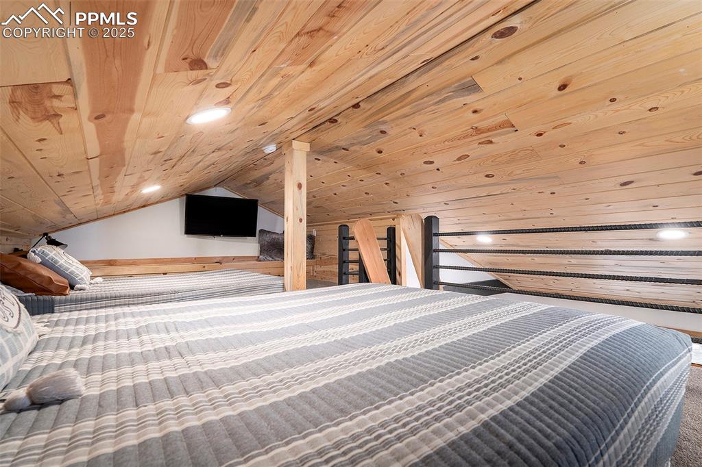 Image 17 of 25: Bedroom featuring vaulted ceiling, wood ceiling, and recessed lighting