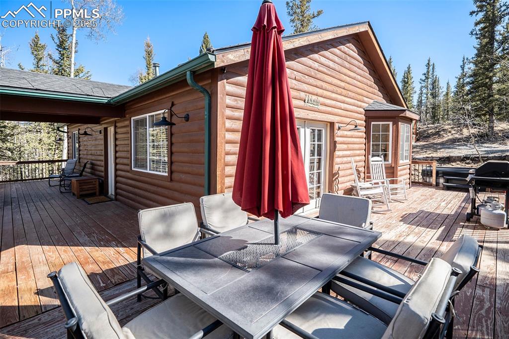 Image 20 of 25: Deck with outdoor dining space and grilling area