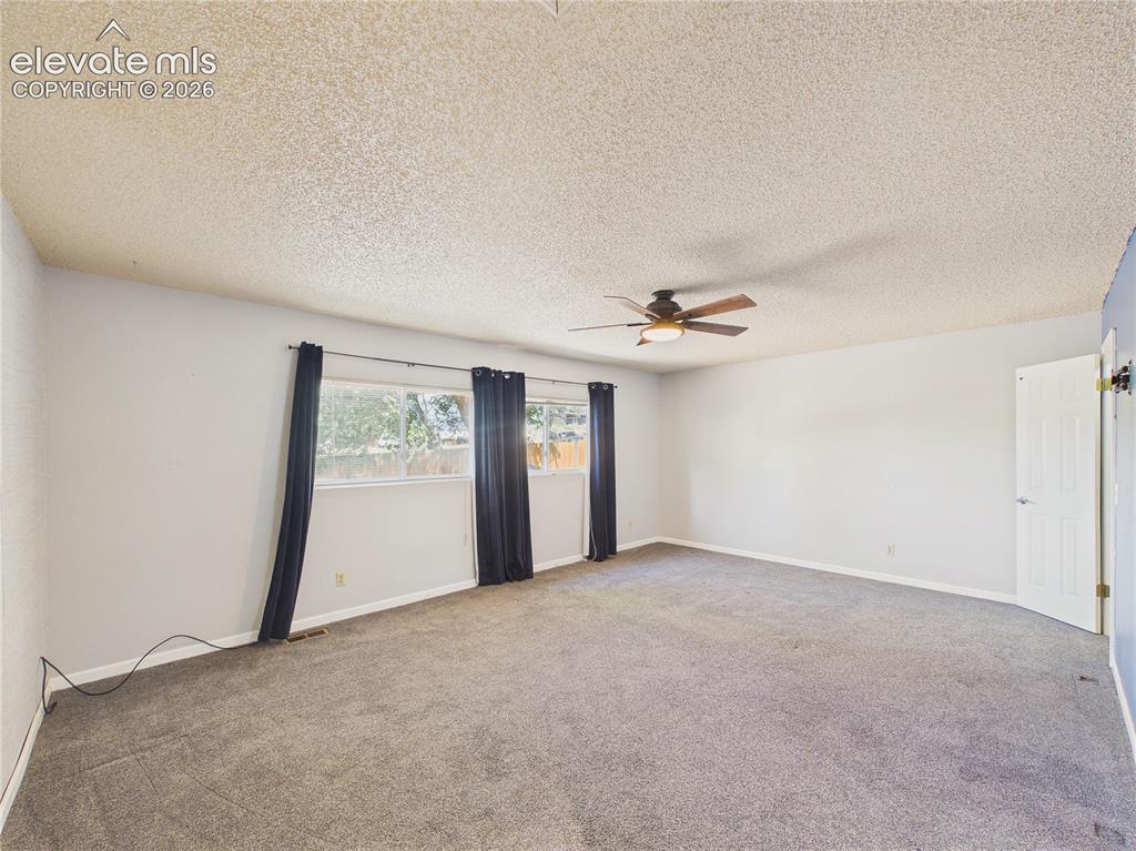 Image 20 of 46: Bright and inviting bedroom with generous floor space and large windows ove