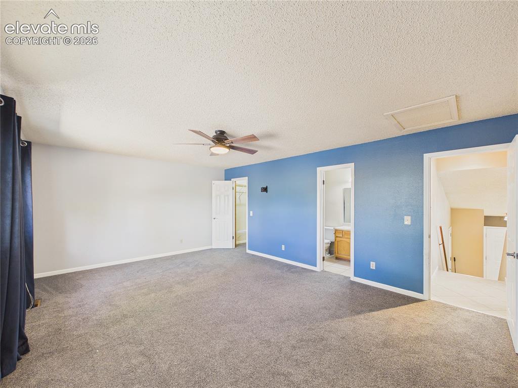 Image 21 of 46: Spacious bedroom featuring plush carpeting, a ceiling fan, and plenty of na