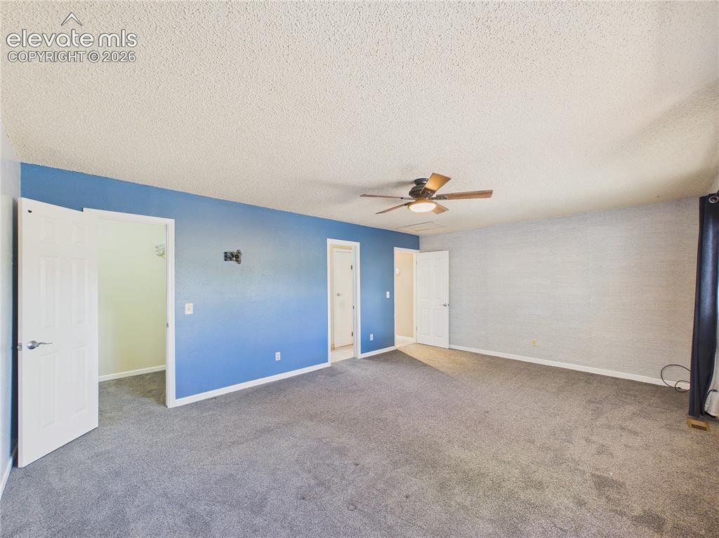 Image 22 of 46: Large primary bedroom with ceiling fan, abundant natural light, and conveni