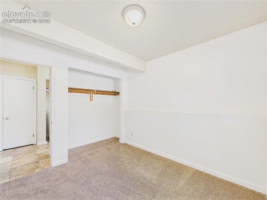 Image 29 of 46: Comfortable bedroom featuring carpeting, ceiling fan, natural light, and a 