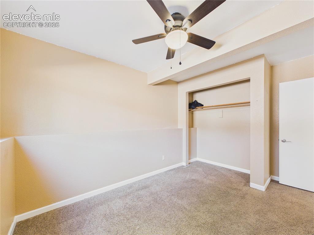 Image 31 of 46: Spacious bedroom with neutral finishes, ceiling fan