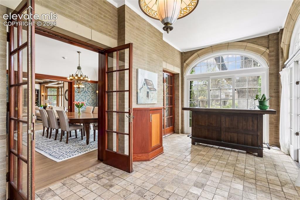 Image 27 of 50: Sunroom off of kitchen and dining room leading to veranda