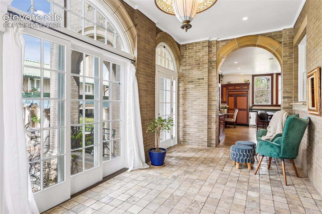 Image 28 of 50: Sunroom off of kitchen and dining room leading to veranda