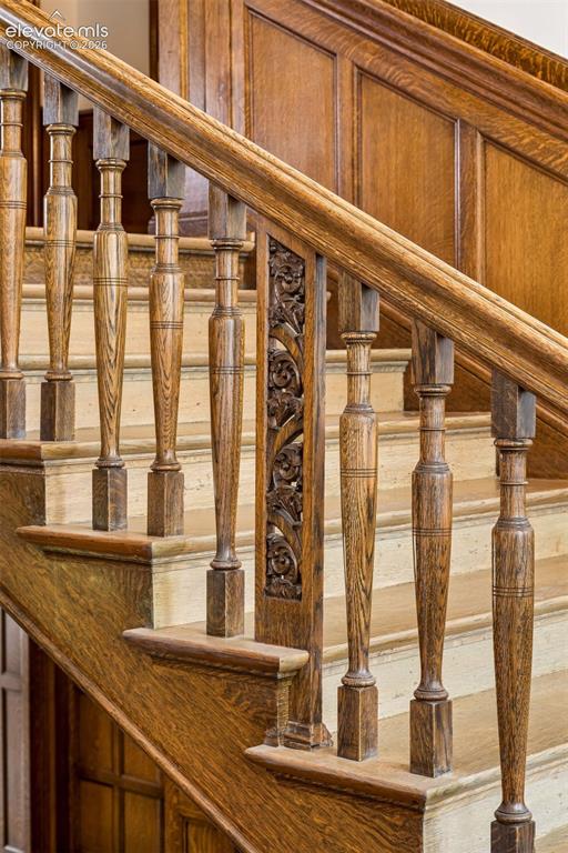 Image 29 of 50: The newel posts are carved in a bell flower pattern, and the balustrades fe