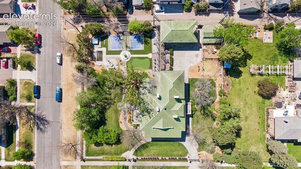 Image 35 of 50: The estate is enclosed by a tall wrought iron fence anchored by stout brick