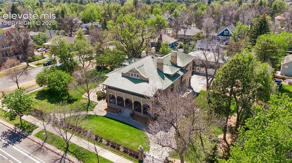 Image 36 of 50: The estate is enclosed by a tall wrought iron fence anchored by stout brick