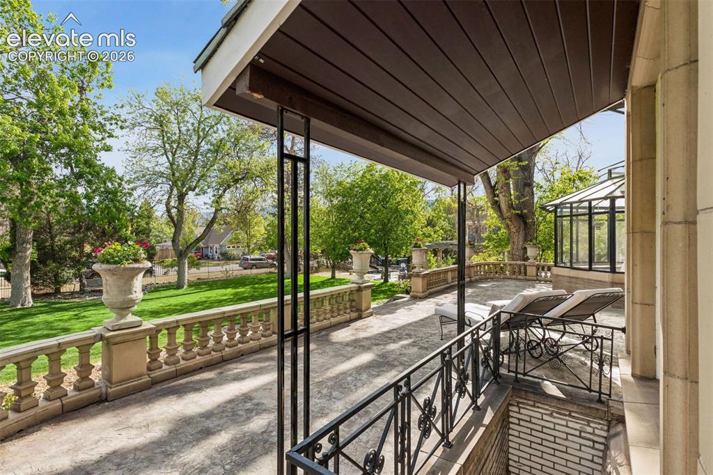 Image 41 of 50: South Porch: A spacious open porch overlooking the lawn’s fountains and per