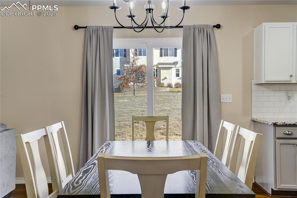 Image 12 of 30: Walk out dining room with modern chandelier