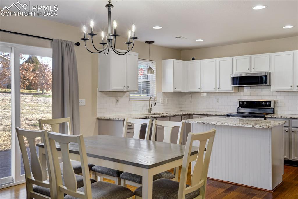 Image 7 of 30: Walk out dining room with modern chandelier 