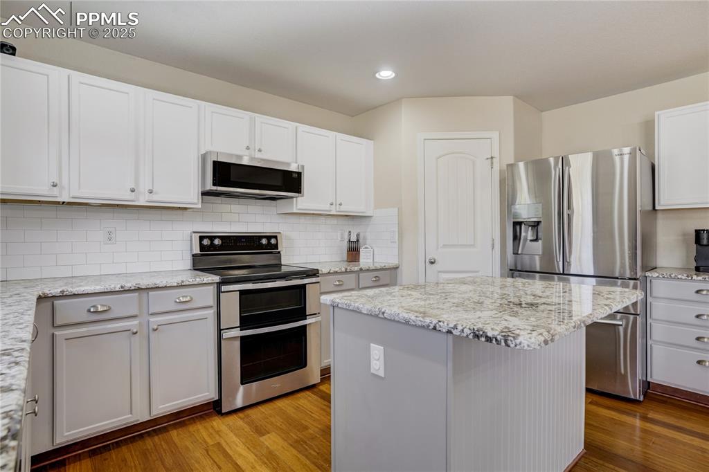 Image 9 of 30: This spacious kitchen offers a private pantry and ample cabinetry