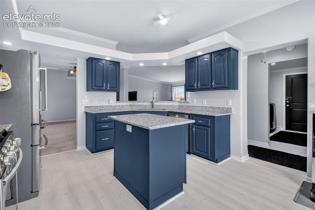 Image 11 of 45: View from kitchen to dining room and family room, view to laundry room. New