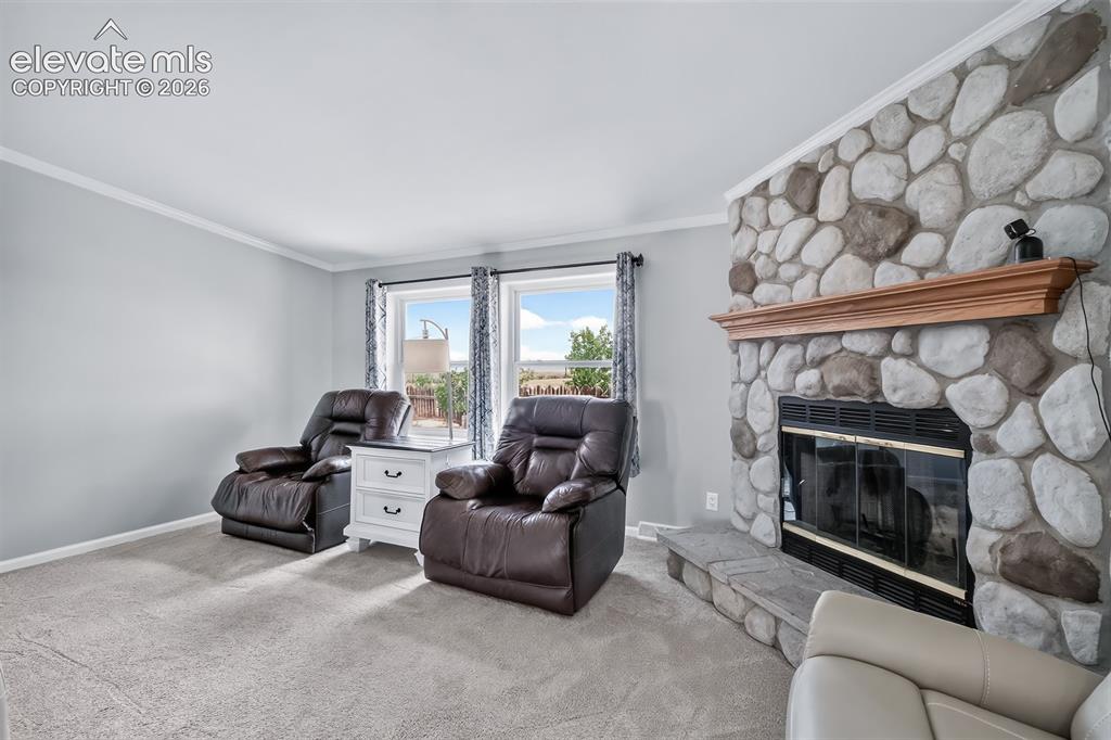Image 12 of 45: Another view of the family room with stone fireplace.