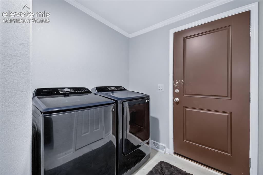 Image 25 of 45: Laundry room with door leading to back yard area.