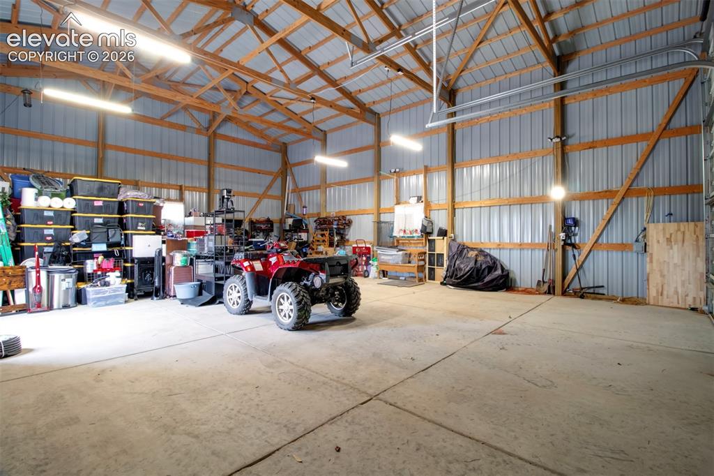 Image 33 of 45: Another view of interior of garage with rollup garage doors and 30 Amp RV c