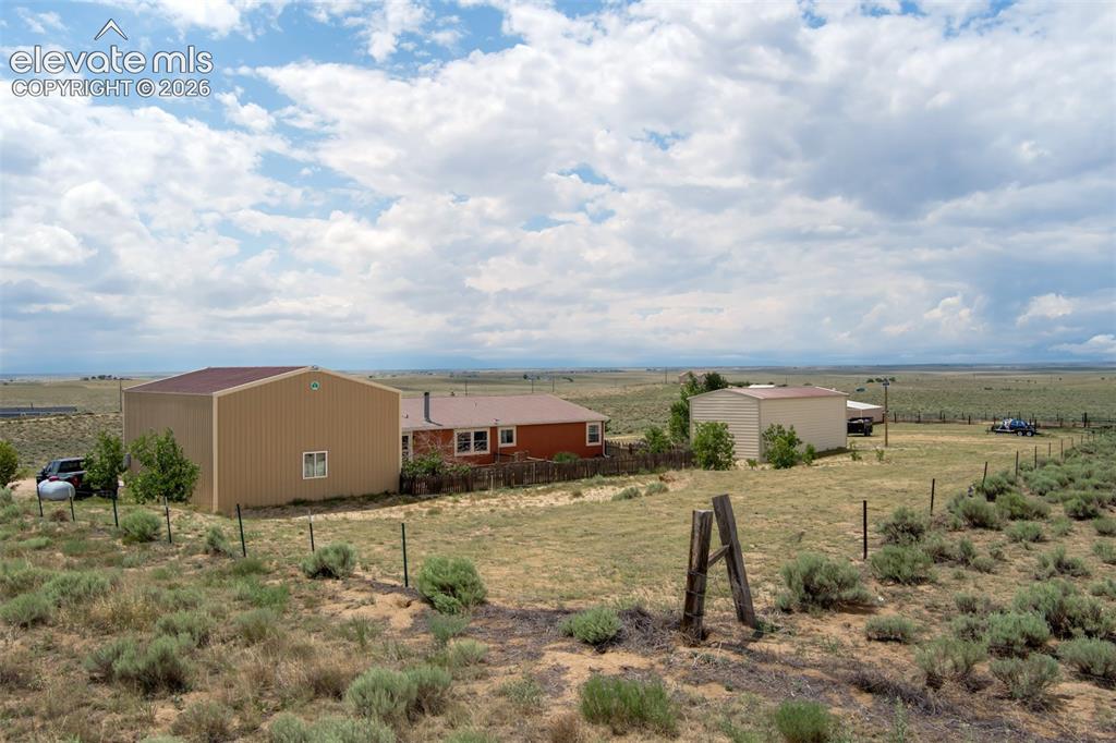 Image 39 of 45: View from back of home to include home, garage and RV building.
