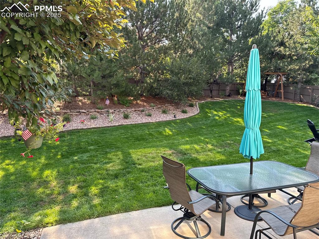 Image 27 of 35: Fenced backyard featuring a patio and outdoor dining area