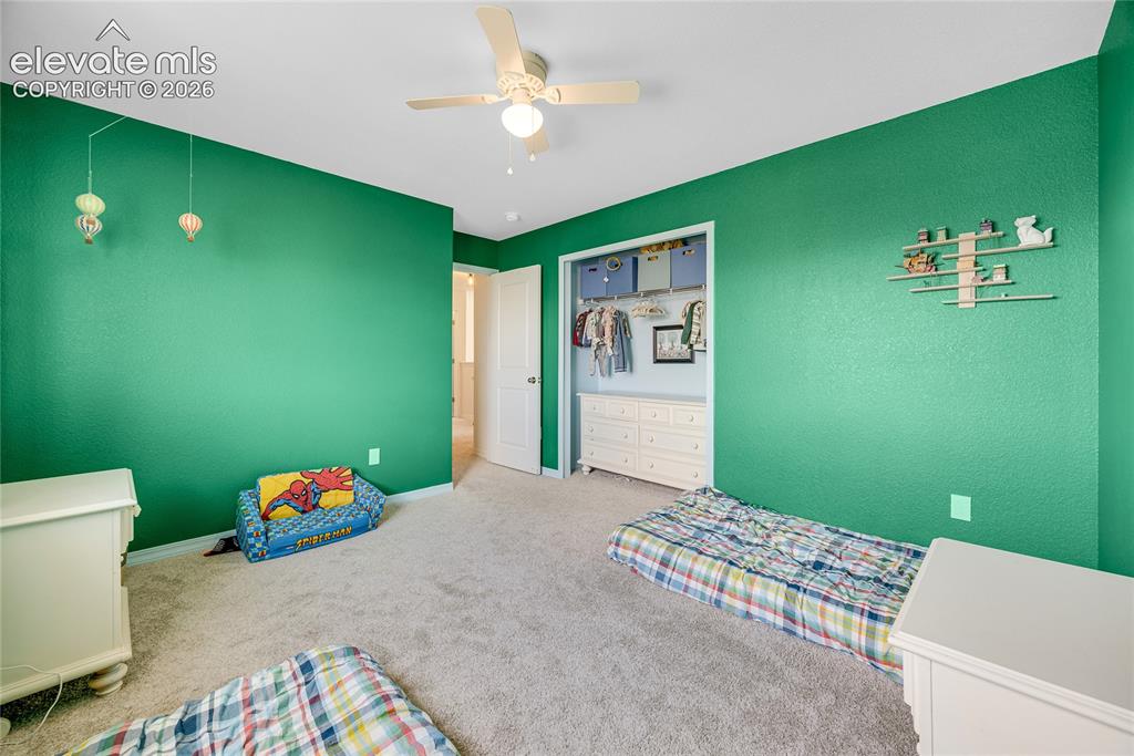 Image 10 of 42: Textured green walls complement neutral carpeting