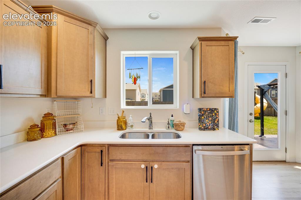 Image 16 of 42: Kitchen featuring light wood cabinetry, a double basin stainless steel sink