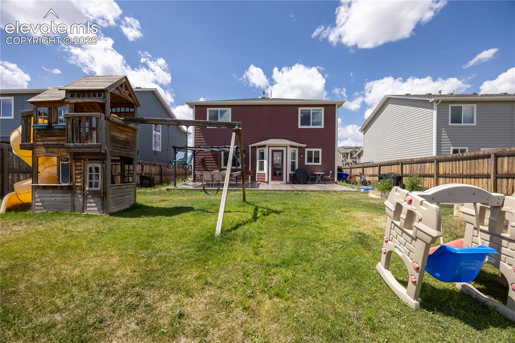 Image 21 of 42: Expansive backyard featuring a lush lawn, privacy fencing, and a built-in p
