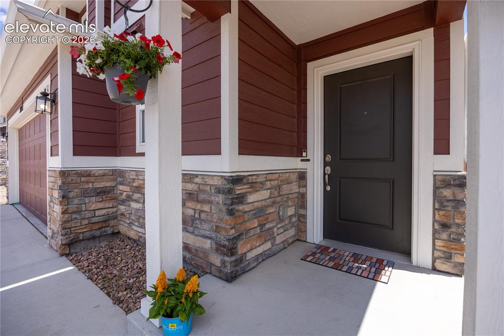 Image 22 of 42: Inviting front entry featuring a paneled black door with white trim