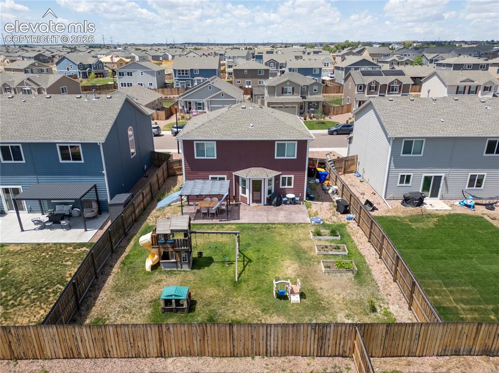 Image 28 of 42: Spacious backyard featuring a wood privacy fence, concrete patio, and multi
