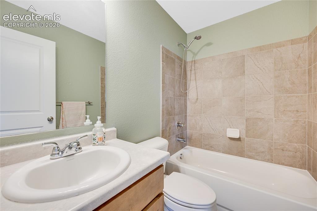 Image 39 of 42: Bathroom featuring a single vanity with an oval undermount sink, chrome fau