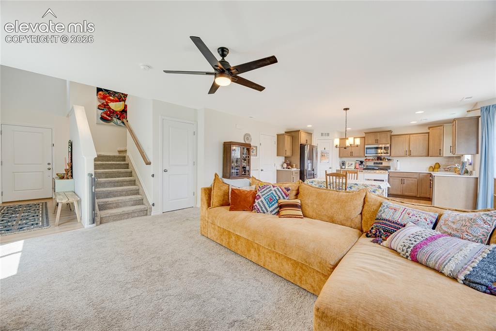 Image 6 of 42: Open-concept living space featuring light carpeting and a contemporary ceil