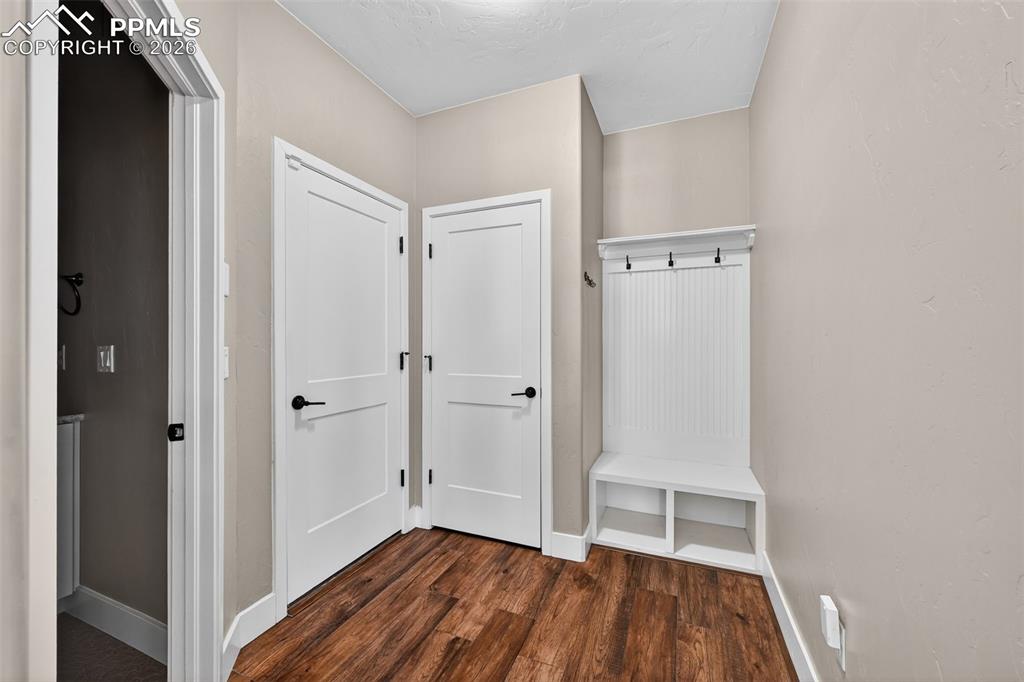 Image 21 of 50: entry from garage into mud room with restroom to the left