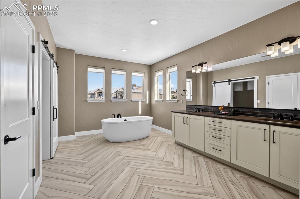 Image 34 of 50: master bath with standalone bathtub, double vanity, shower