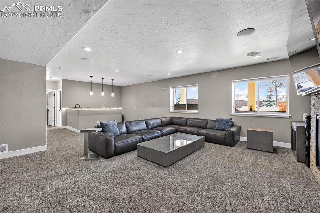 Image 41 of 50: lower level living room area with open concept and wet bar