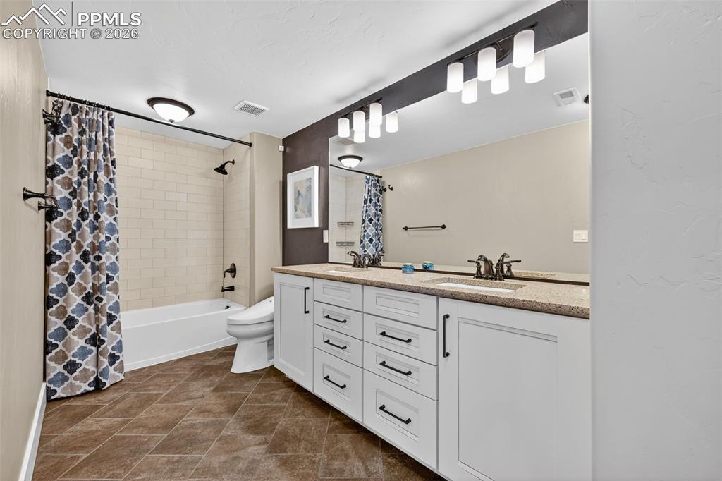 Image 46 of 50: lower level double vanity bathroom with bathtub/shower combo