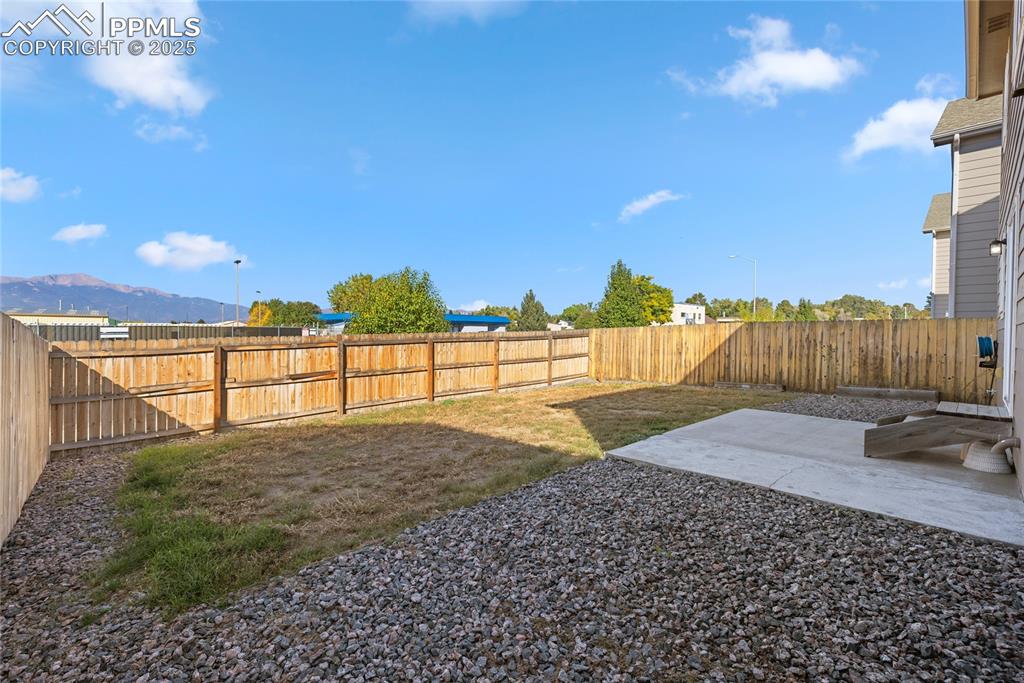 Image 15 of 24: Fenced backyard with a patio area and a mountain view