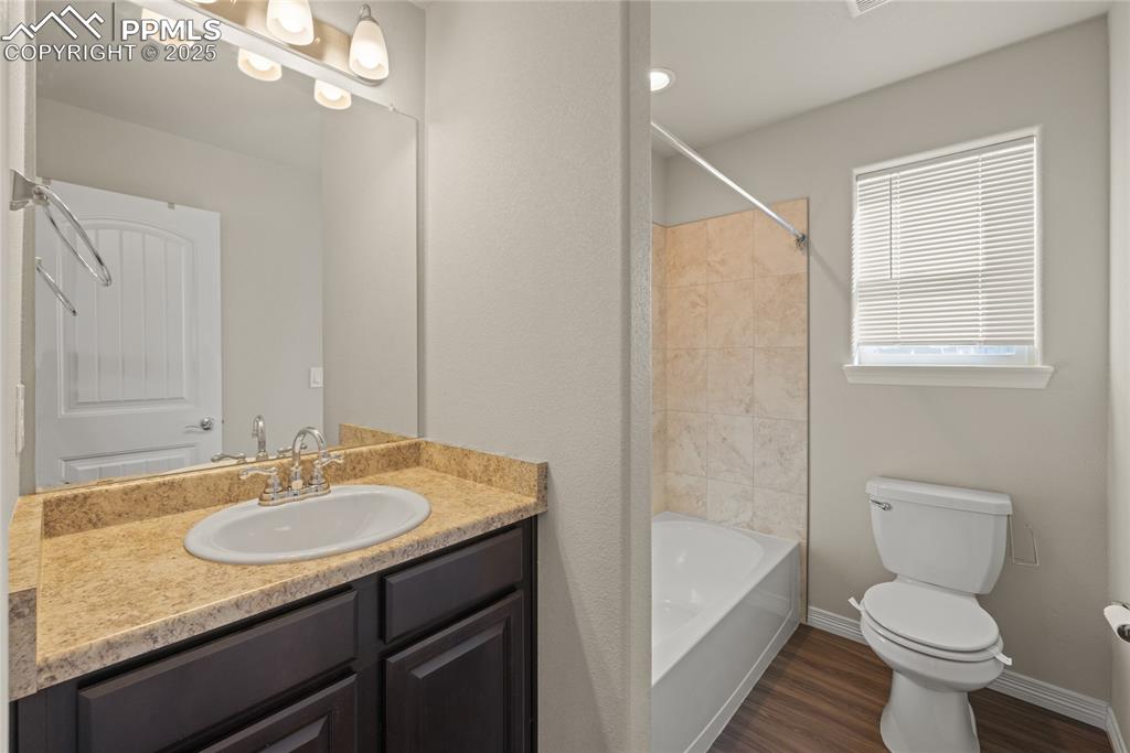 Image 19 of 24: Bathroom featuring vanity, dark wood-style floors, and tub / shower combina