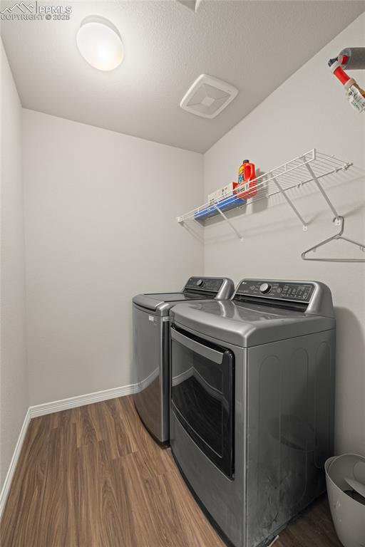 Image 22 of 24: Laundry area featuring dark wood-type flooring, washer and dryer, and a tex
