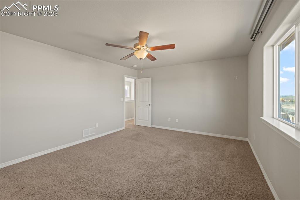 Image 23 of 24: Carpeted empty room featuring baseboards and ceiling fan
