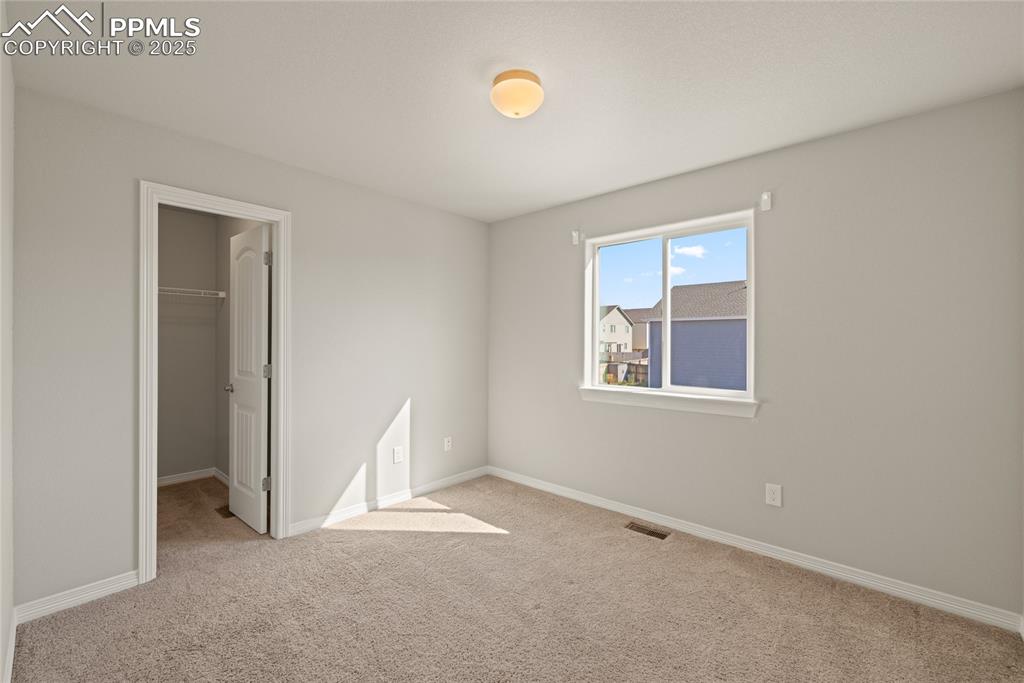 Image 24 of 24: Unfurnished bedroom with a spacious closet and light colored carpet