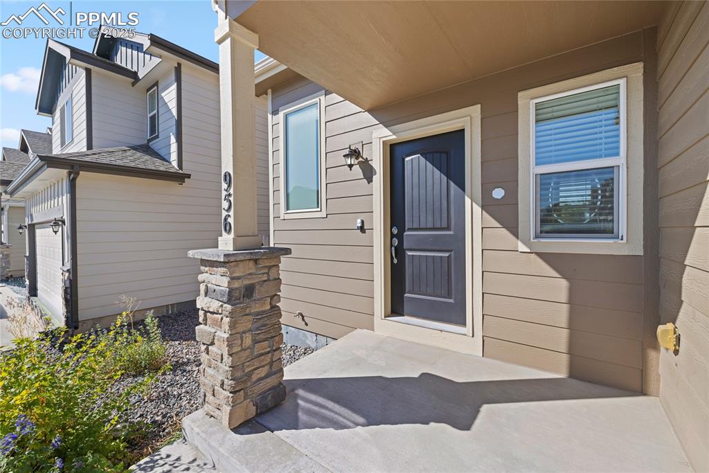 Image 4 of 24: Entrance to property with a shingled roof and an attached garage