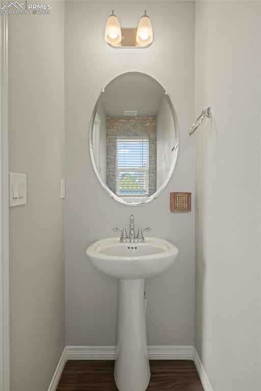 Image 7 of 24: Bathroom featuring baseboards and dark wood-style floors