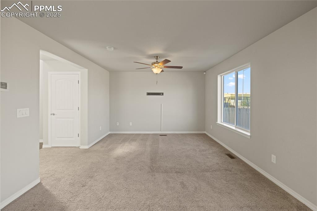 Image 8 of 24: Unfurnished room featuring light carpet and ceiling fan