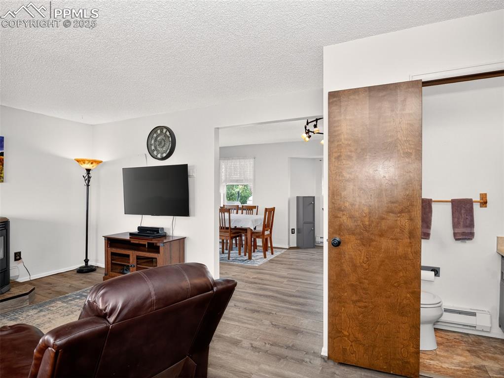Image 7 of 45: Living room with conveniently located half bathroom
