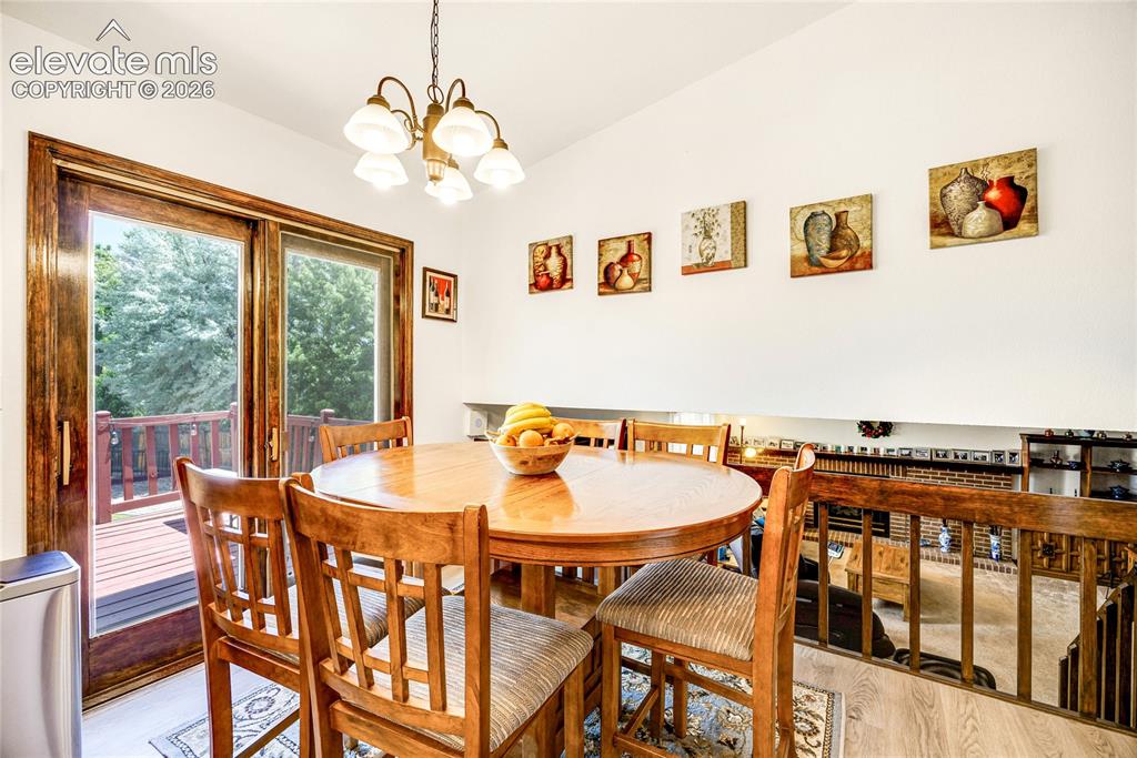 Image 13 of 46: Dining area with vaulted ceilings and wood-finish flooring