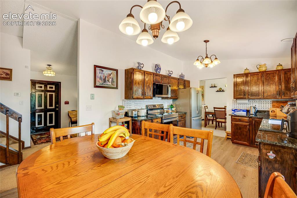 Image 14 of 46: Open-concept kitchen and dining area featuring wood-finish flooring, rich w