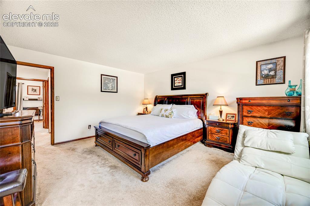 Image 16 of 46: Carpeted bedroom featuring white walls and a textured ceiling