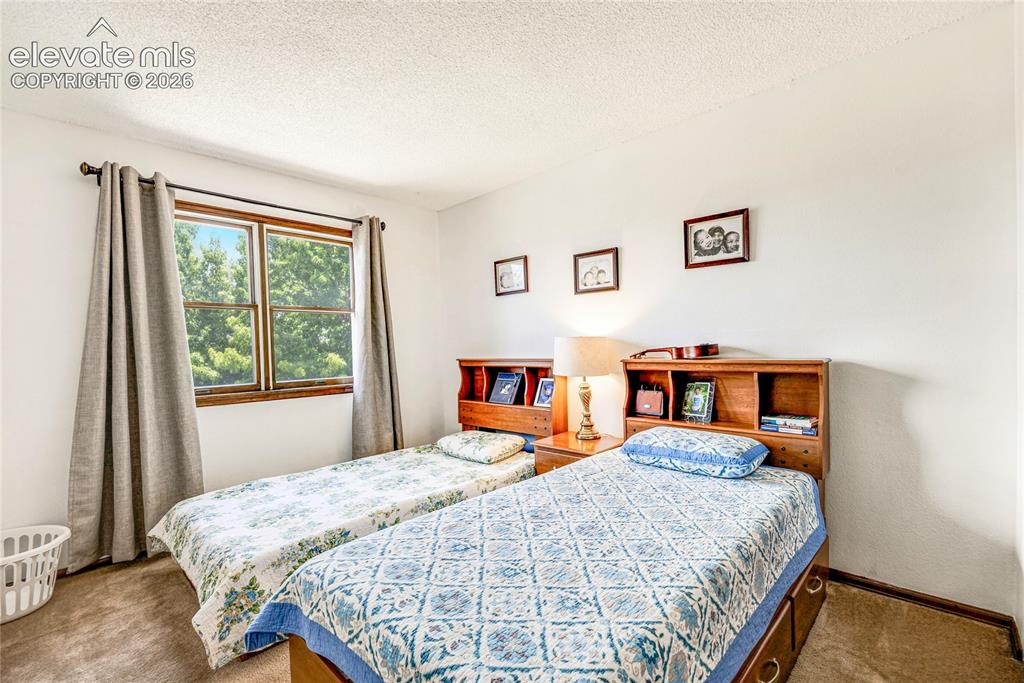 Image 19 of 46: Bedroom featuring a double-paned window, neutral wall paint, and textured c