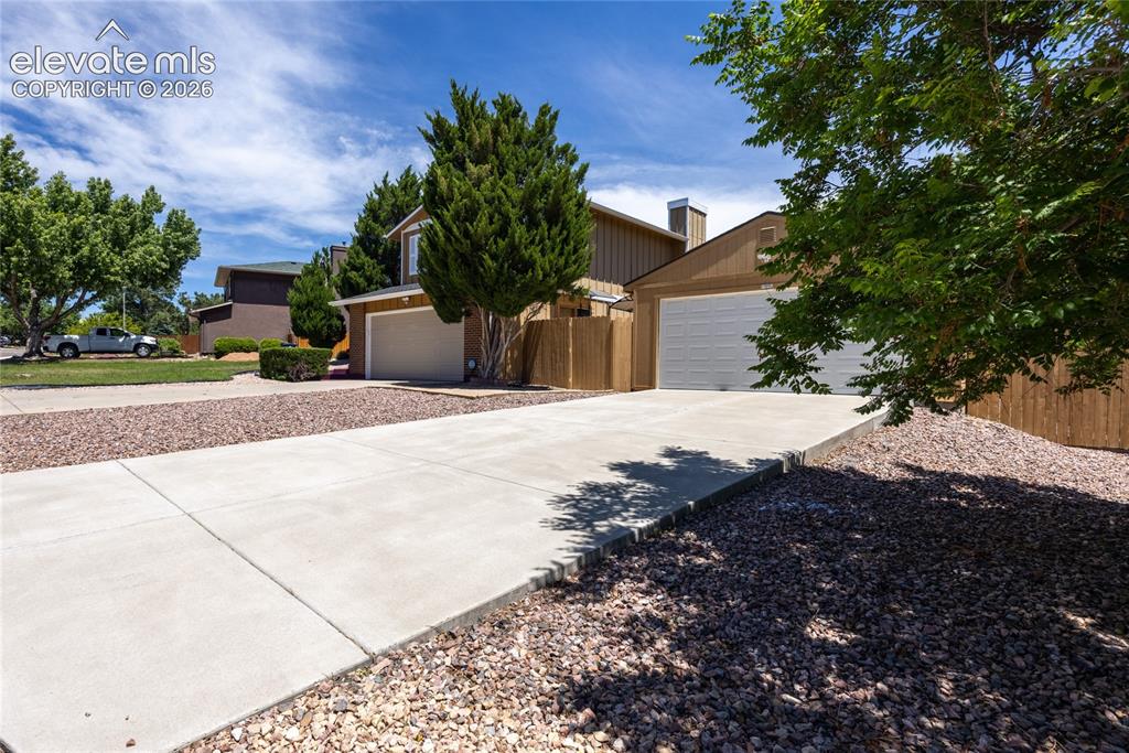 Image 2 of 46: Two-story residence featuring a two-car garage with a white garage door, a
