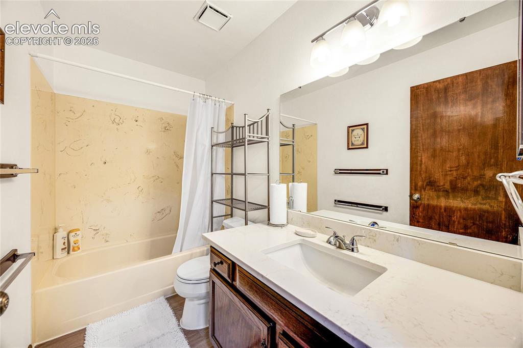 Image 23 of 46: Bathroom featuring a vanity with an integrated sink, a large wall-mounted m