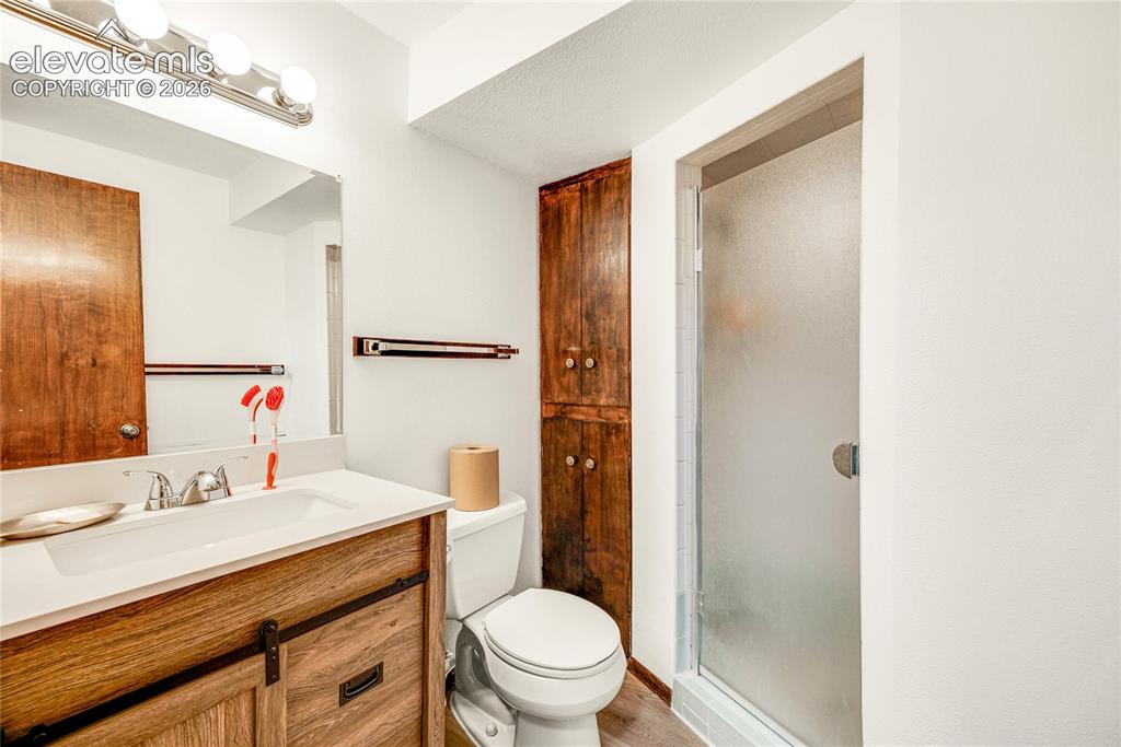 Image 28 of 46: Bathroom featuring a wood-finish vanity with a white countertop and integra